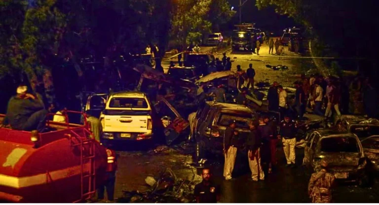 Blast scene near Karachi Airport after a suicide bombing targeting a vehicle carrying Chinese nationals, with emergency responders attending to the injured.